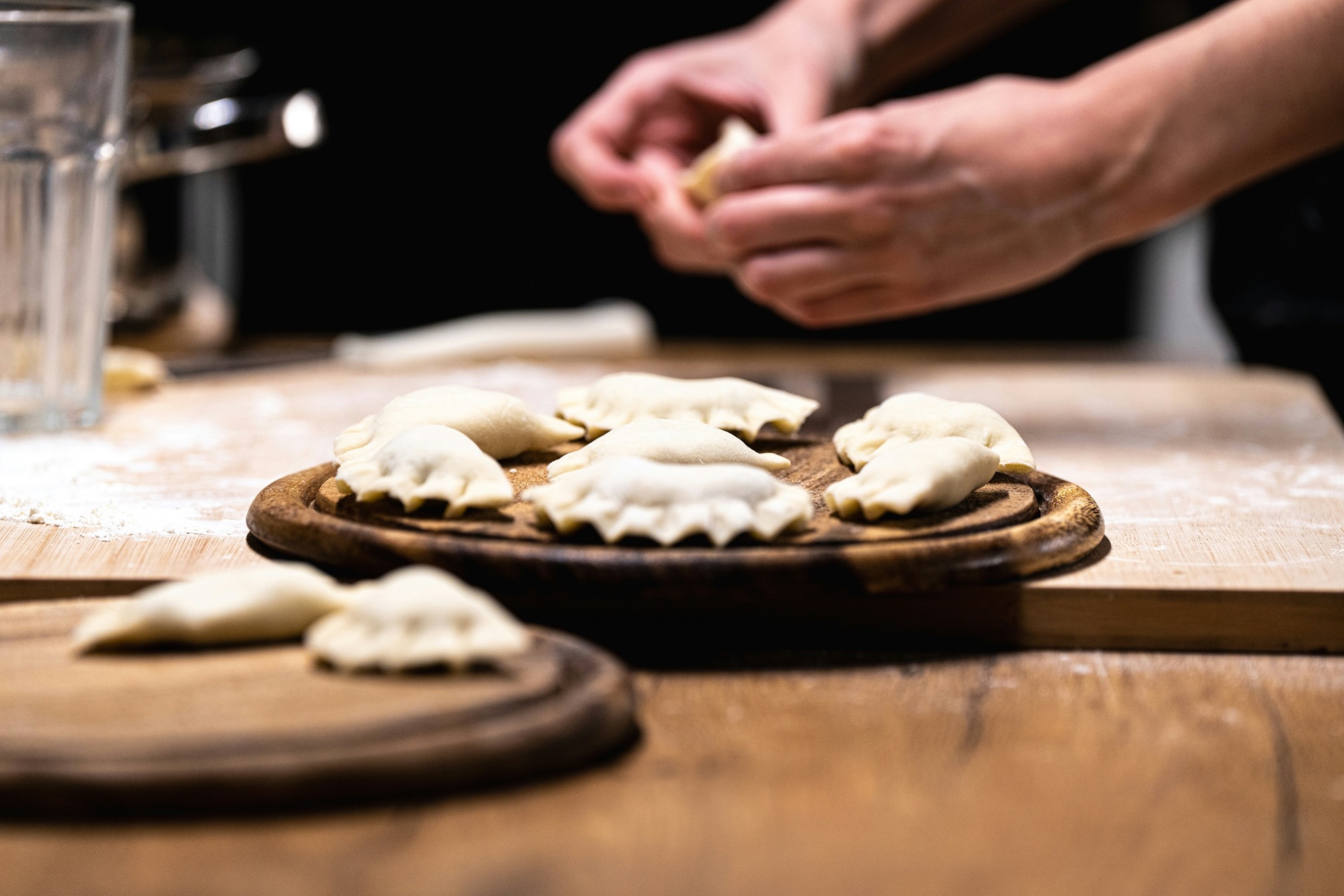 Day 8 — Hands folding empanadas during a cooking class