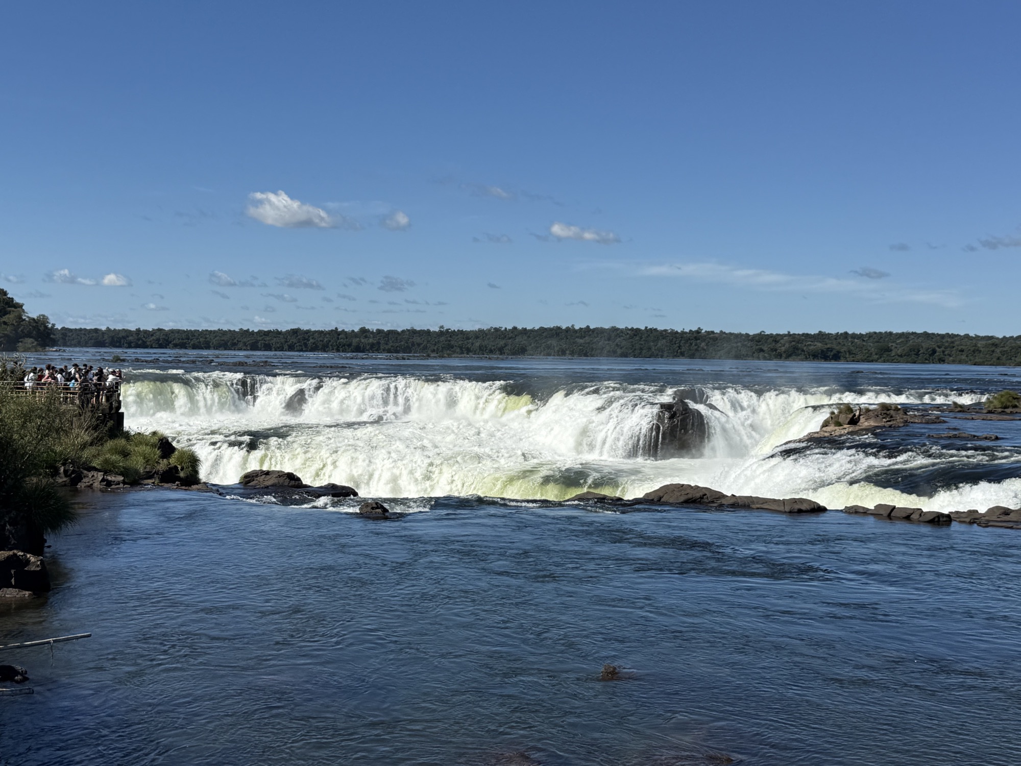 Wide view of the Iguazú River rushing over the falls