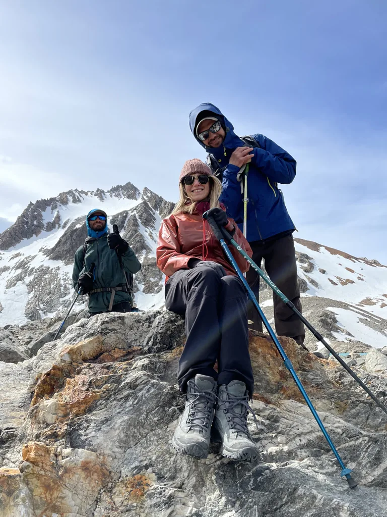 A traveler and mountain guides sharing the summit experience