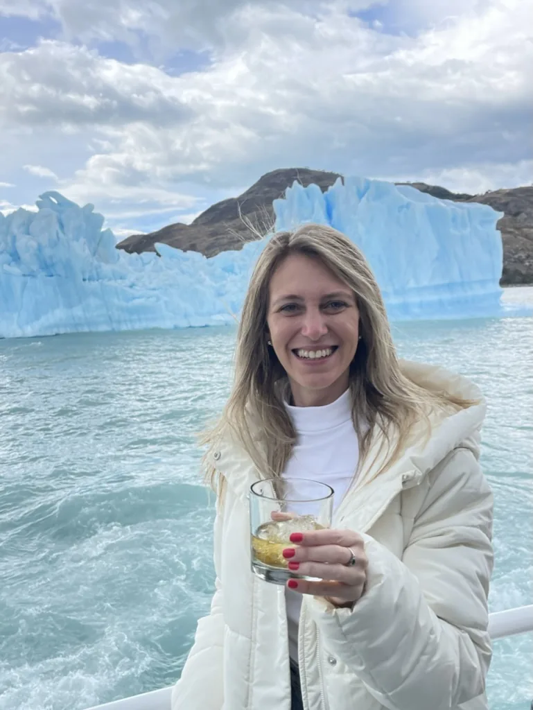 A traveler enjoying a drink in front of a glacier